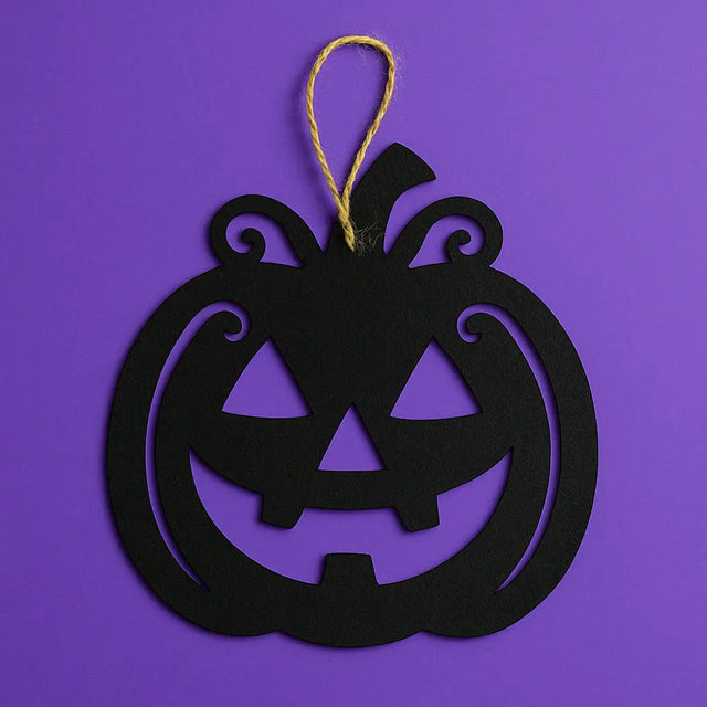 Black jack-o'-lantern wall hanging with swirling vine details, suspended by twine, perfect for Halloween wall or window decorations.