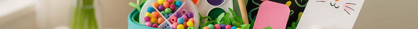 Colorful Easter basket filled with paints, beads, and crafts, styled for kids as a fun and creative non-candy alternative to traditional Easter gifts.