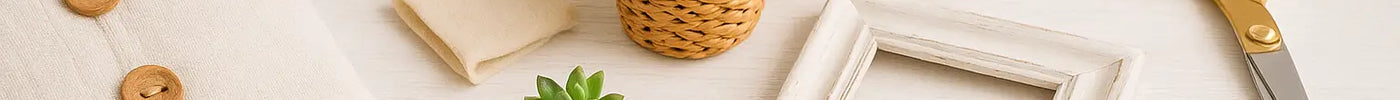 Flat lay of discount store DIY home decor items including pillow, chalk paint, wood, rattan planters, and tools.