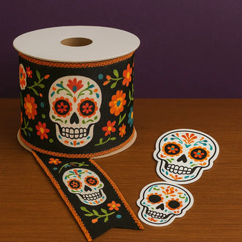 Day of the Dead ribbon spool with sugar skull and floral pattern, alongside colorful sugar skull stickers—perfect accessories for crafts, gifts, and Día de los Muertos decor.