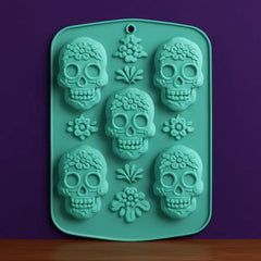 Light turquoise silicone baking mold with sugar skull shapes for Day of the Dead treats, perfect for Día de los Muertos themed cookies, chocolates, and crafts.