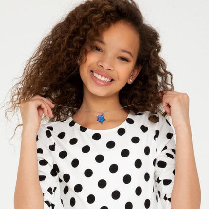 Smiling girl wearing a handmade crystal necklace from the YOUniverse Crystal Growing Jewelry Kit, showcasing a colorful star-shaped pendant
