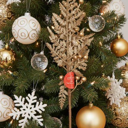Ashland gold glitter Christmas pick spray 16 inch tucked into a Christmas tree among gold and white ornaments with fairy lights