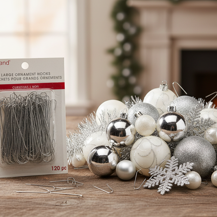 Ashland large silver Christmas ornament hooks next to silver and white Christmas ornaments on a wooden surface