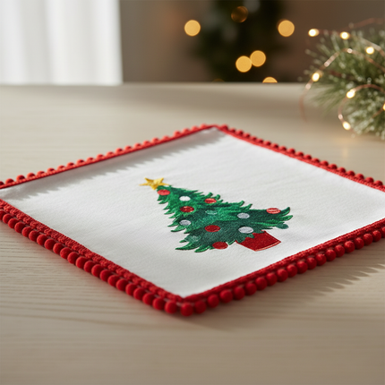 Close-up of white cloth napkin showing Christmas tree design and red crochet scalloped border detail
