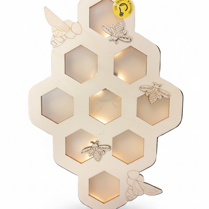 DIY unfinished natural wood honeycomb shaped wall hanging with hexagon cutouts and laser-cut bee accents on white background
