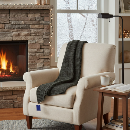 Dark black grey textured knit winter scarf draped elegantly over a chair in a cozy winter home interior setting
