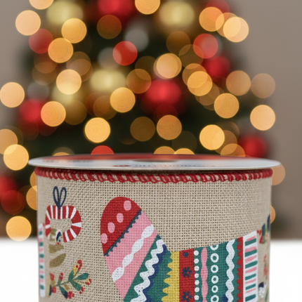 Close up of Celebrate It Christmas wired ribbon showing natural burlap texture and colorful Christmas stocking pattern detail in red pink teal and yellow with red zigzag edges