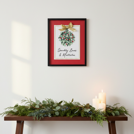Sparkly Bows and Mistletoe framed wall decor hung above a console table with Christmas greenery and candles