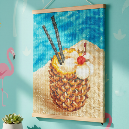 Completed pineapple drink diamond art canvas in wooden hanger frame displayed on a bright summer-themed wall