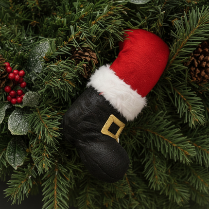 Close-up of Ashland plush Santa leg pick with black boot and gold buckle detail inserted into Christmas greenery