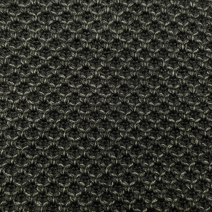 Close-up of dark black grey textured knit fabric detail on winter scarf showing waffle knit texture pattern