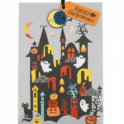 Close-up of Halloween treat bag showing haunted castle with jack-o-lanterns, ghosts and black cat illustration with decorative pin and gift tag