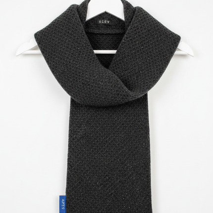 Apt. 9 dark black grey textured knit winter scarf draped over a white wooden hanger against a white wall