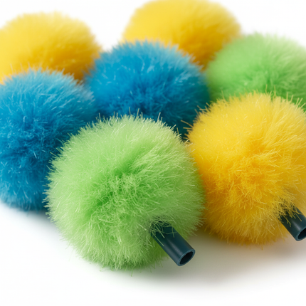 Close-up of fuzzy pom-pom pencil toppers in bright teal, blue, green, and yellow showing soft fluffy texture