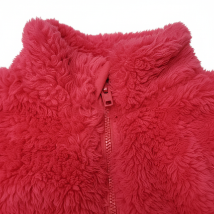 Close-up of red fuzzy fleece fabric texture and 1/4 zip detail on a girls pullover sweater