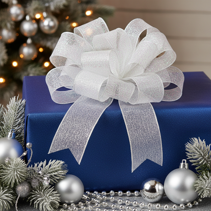 Celebrate It white glitter ribbon 2.5in x 20ft formed into a large sparkling bow on a wrapped Christmas gift with silver ornaments and pine branches
