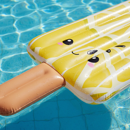 Close-up of giant inflatable lemon popsicle pool float showing cute kawaii face and yellow criss-cross pattern detail