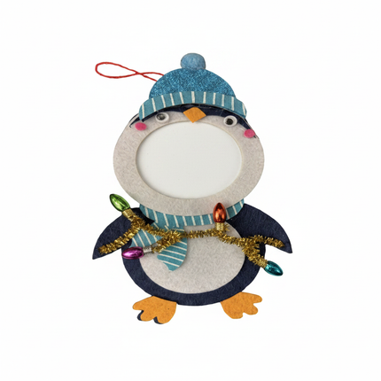 Close up detail of felt penguin ornament blue glitter beanie and colorful Christmas lights