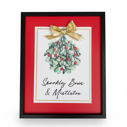 Framed wall decor with black frame, red mat, watercolor mistletoe illustration, gold bow and Sparkly Bows & Mistletoe script on white background